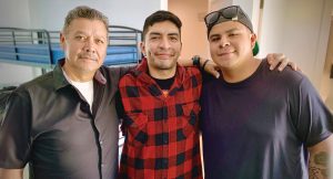 Jorge (center) was on the streets and struggling with addiction before coming to the program
