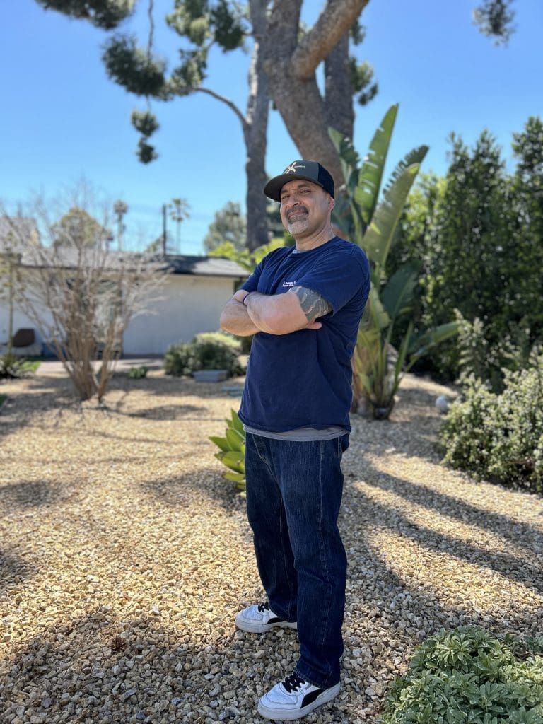 Jose, standing in yard, smiling