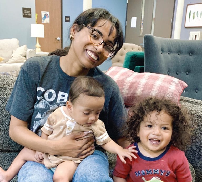 Smiling woman with two young children at San Fernando Rescue Mission.
