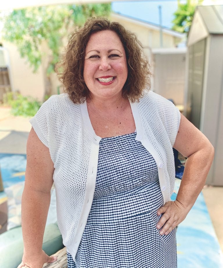Happy woman smiling outdoors at San Fernando Rescue Mission event.