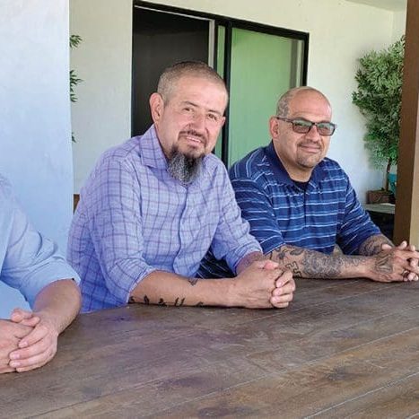 Felix, who entered the program in March, seated at left with other program residents, as well as program manager Oscar Corral (far right).