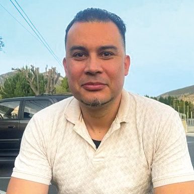A smiling man outdoors at San Fernando Rescue Mission in California.