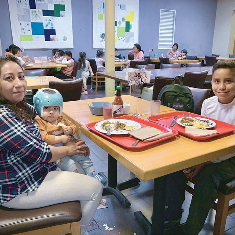 women and children at table eating