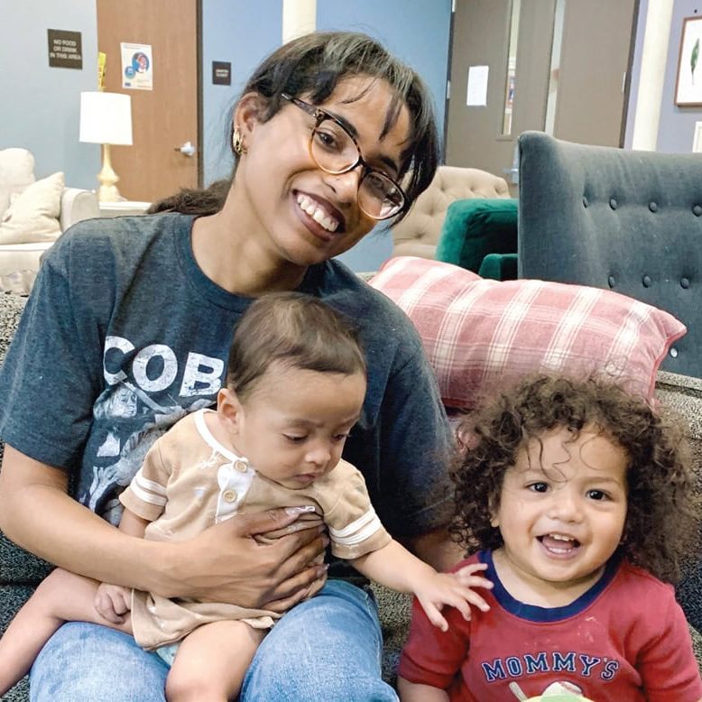 Smiling woman with two young children at San Fernando Rescue Mission.
